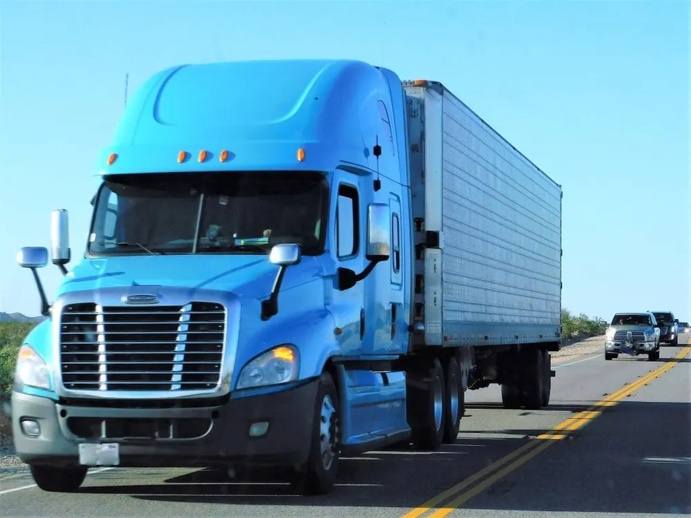 Blue Freightliner Cascadia on the road